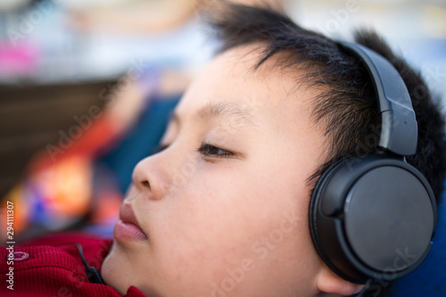Close up of Asian boy listen to music via headphone