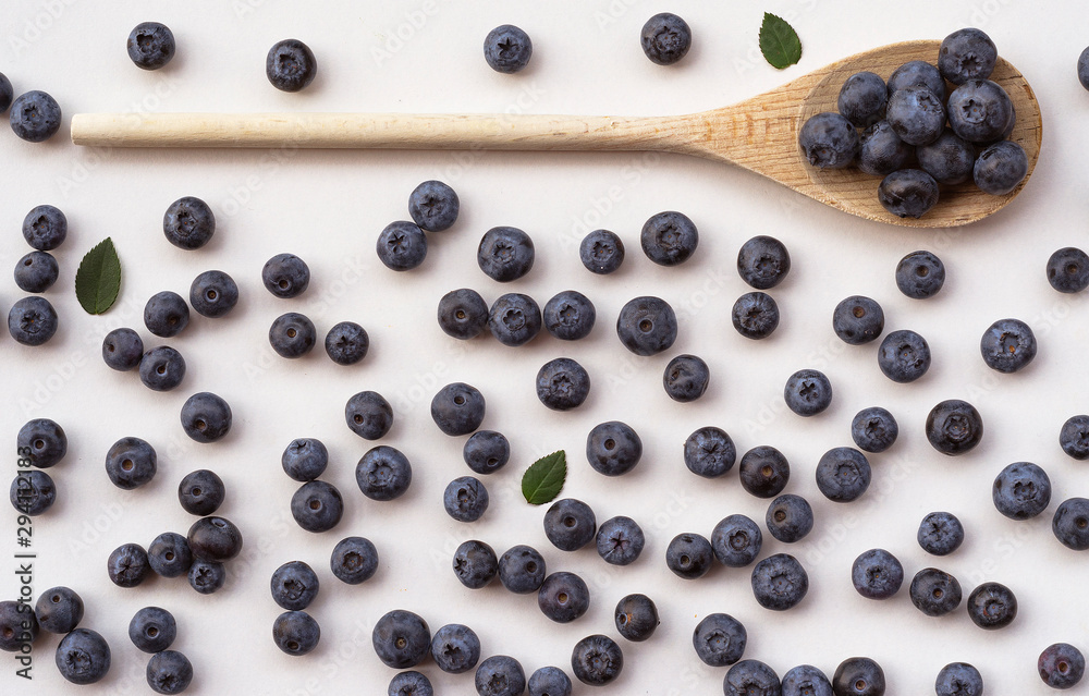 blueberries in a wooden spoon on a white background blueberries in a wooden spoon on a white background