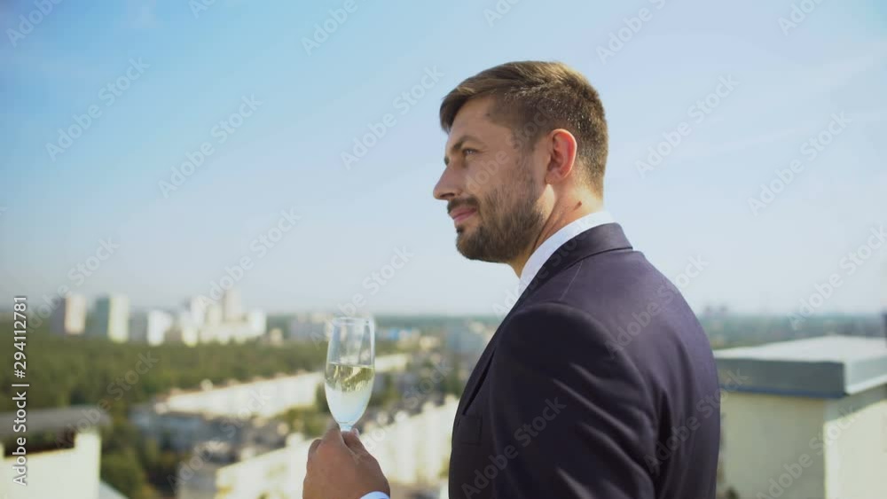 Glad company specialist celebrating work success drinking champagne on terrace Glad company specialist celebrating work success drinking champagne on terrace