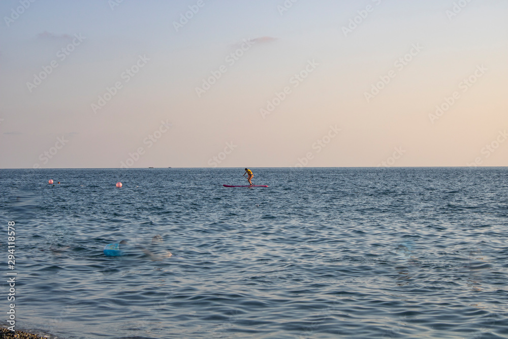 Skating on a surfboard in the evening on the Black Sea near the city of Sochi