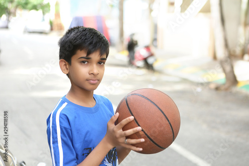 Portrait of Indian boy holding basketball