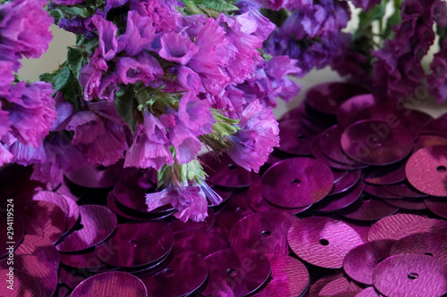 Detail of purple round sequins and purple dried flowers.