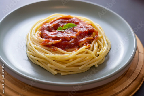 Spaghetti pasta with tomatoes sauce and basil in plate on dark background. Pasta plate isolated.