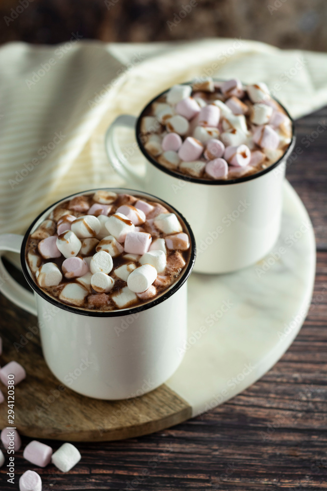 Two cups of hot chocolate, cocoa or warm drink with marshmallows on dark background Two cups of hot chocolate, cocoa or warm drink with marshmallows on dark background