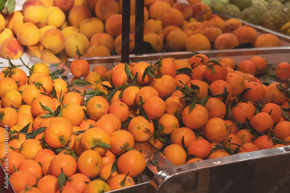 tangerines with leaves on a market counter