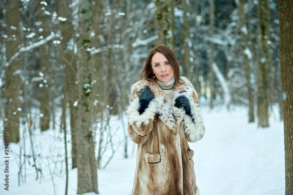 Beautiful young woman in furs. Snowy winter forest background. Beautiful young woman in furs. Snowy winter forest background.
