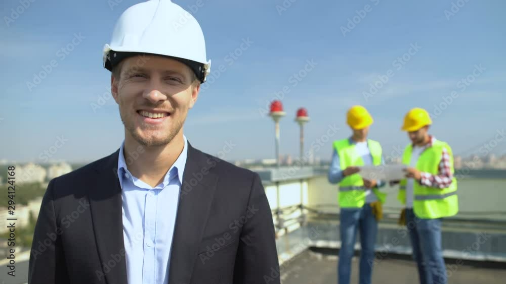 Smiling construction engineer in safety helmet looking camera, skilled architect Smiling construction engineer in safety helmet looking camera, skilled architect