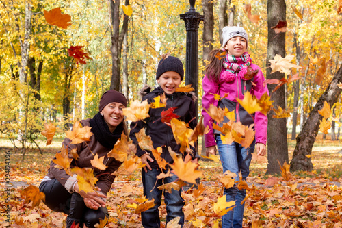 happy family playing with fallen leaves in autumn park © Sergei Zub