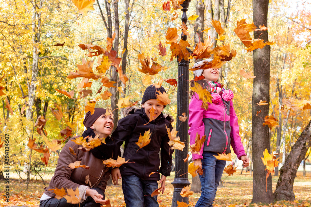 happy family playing with fallen leaves in autumn park happy family playing with fallen leaves in autumn park