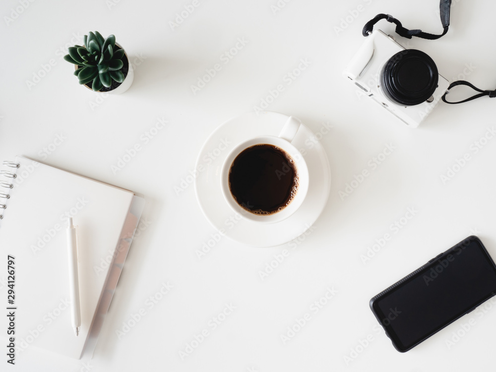 top view of office desk table with coffee cup, notebook, laptop, plastic plant, smartphone and keyboard on white background, graphic designer, Creative Designer concept.
