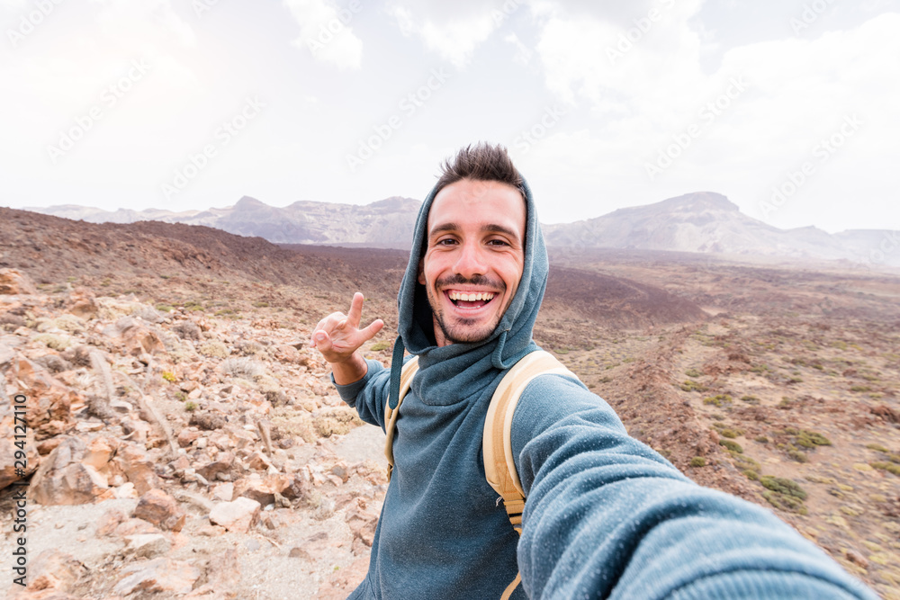 Happy hiker takes a selfie on the top of the mountain.