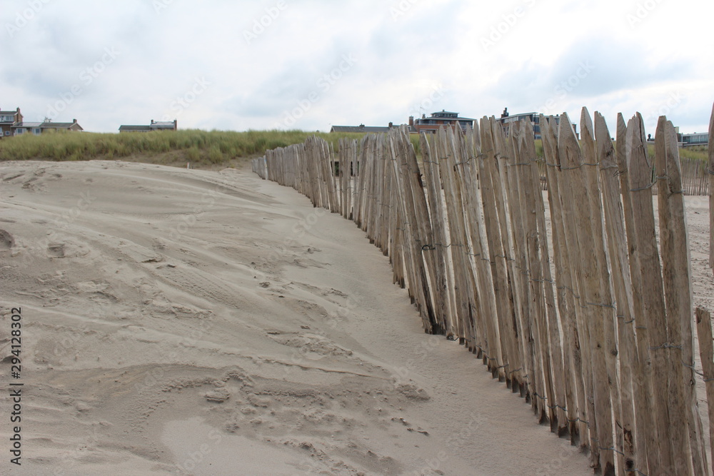Holzzaun mit Sand vom Strand umgeben