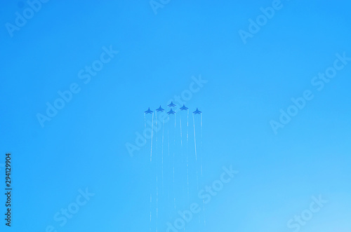 Aerobatics. Planes in the blue sky. Traces of aircraft in the sky. Drawings on the sky.