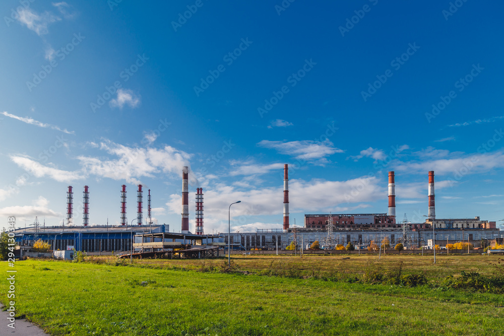 Pipes of a Plant from which there is Smoke Against the Blue Sky on a Sunny Day. Pipes of a Plant from which there is Smoke Against the Blue Sky on a Sunny Day.