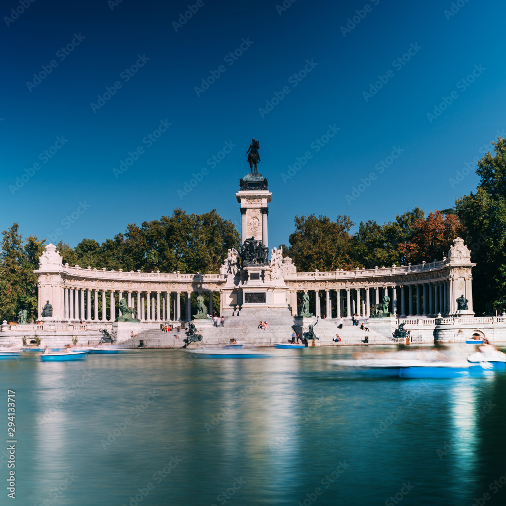Long exposure of people on boats across from monument to Alfonso XII in the Parque del Buen Retiro, in Madrid, Spain