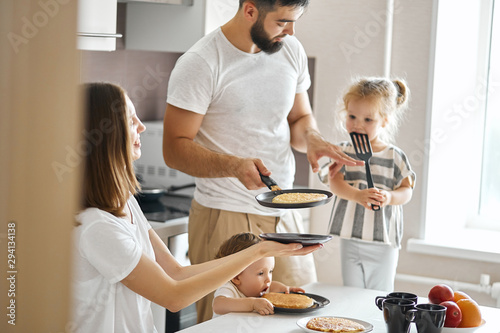 Fototapeta Naklejka Na Ścianę i Meble -  talented husband treting his family with yummy pancakes in the morning, daily life, free time, spare time, lifestyle