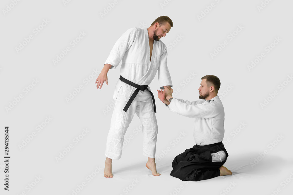 Two caucasian men are practicing aikido on the tatami (isolation path included) Two caucasian men are practicing aikido on the tatami (isolation path included)