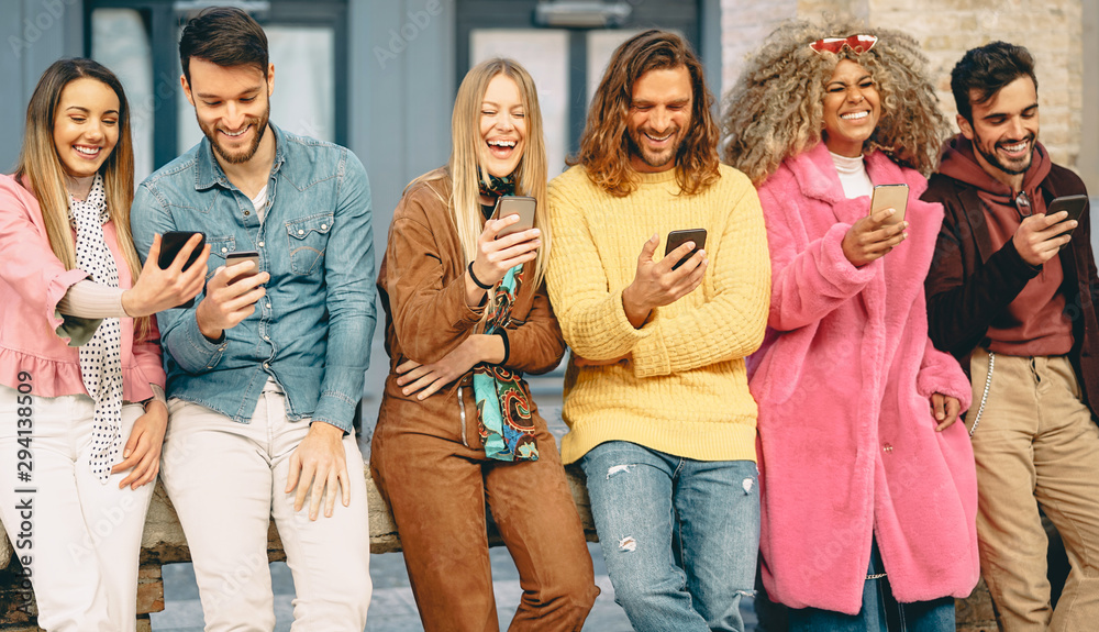 Obraz premium Group of trendy friends using mobile smartphones outdoor - Millennial young people having fun with new technology apps for social media - Concept of youth culture generation z and technology