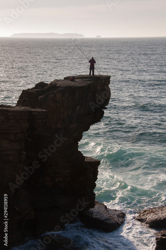 Persona pescando en lo alto de una gran roca