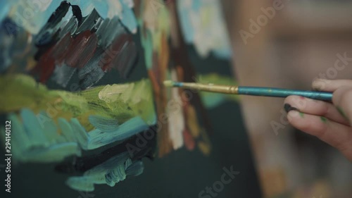Detail view of brush of artist, touching canvas, drawing a picture