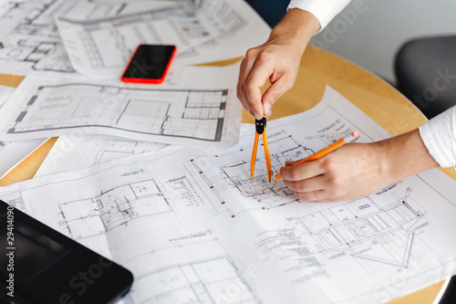 Male architect drawing blueprints in office workplace