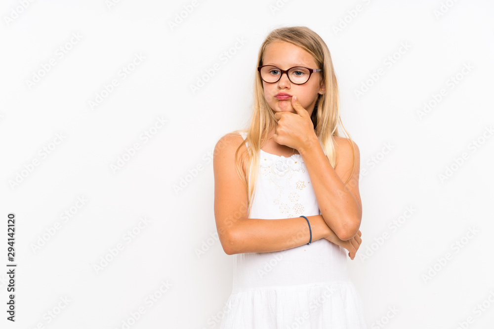 Little girl over isolated white wall having doubts Little girl over isolated white wall having doubts
