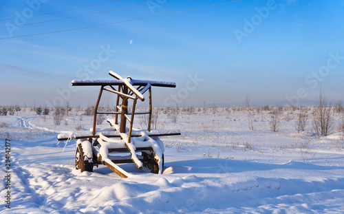 Farm equipment on winter meadow in daylight