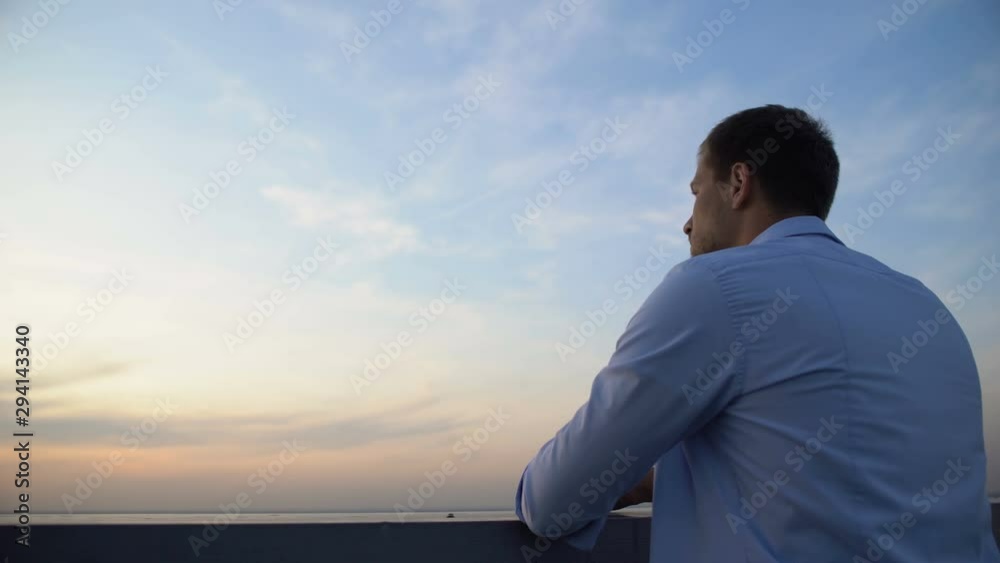 Pensive Caucasian man enjoying sky view from terrace, thinking about life Pensive Caucasian man enjoying sky view from terrace, thinking about life