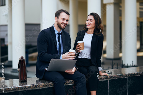 Fotografia young office workers sitting outdoors and entertaining each other, close up phot