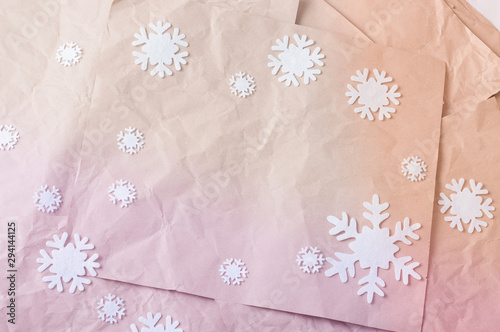 Pile of colorful rumpled kraft paper lying in disorder with white woolen snowflakes. © Valentina