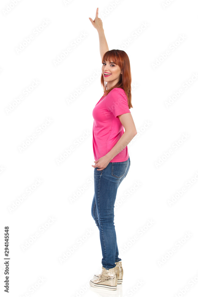 Young Woman Is Pointing Up And Talking. Side View. Young Woman Is Pointing Up And Talking. Side View.