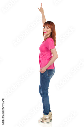 Young Woman Is Pointing Up And Talking. Side View.