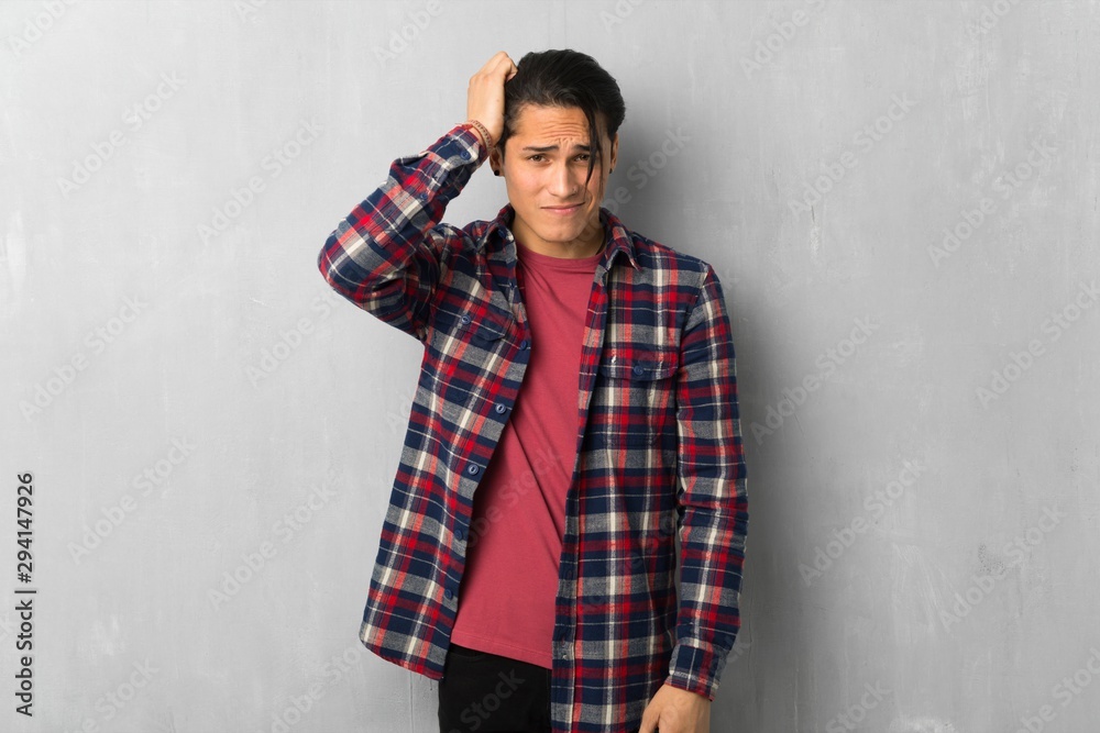 Obraz premium Man over grunge wall with an expression of frustration and not understanding