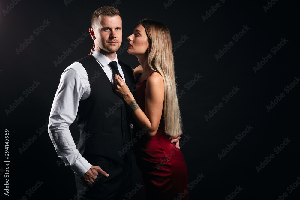 Obraz premium sexual woman seducting a businessman. isolated black background, studio shot,copy space. seductive art. close up portrait, studio shot