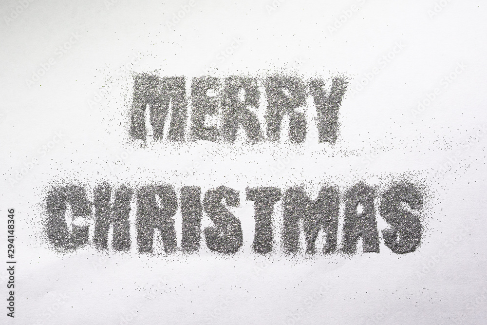 Christmas inscription in silver sequins on white background Christmas inscription in silver sequins on white background