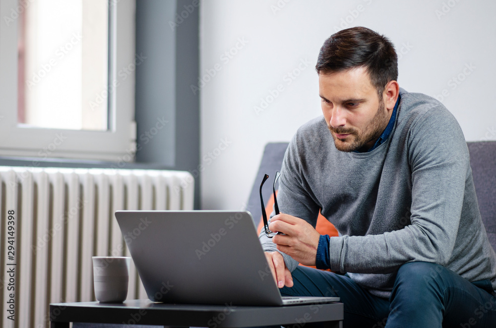 Young freelancer looking worried and serious while dealing with a work problem