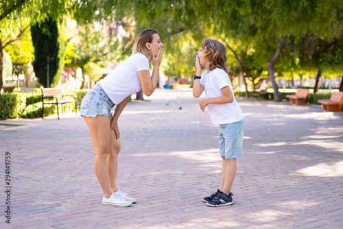Mother and son in a park doing surprise gesture
