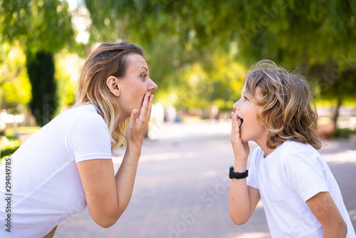 Mother and son in a park doing surprise gesture
