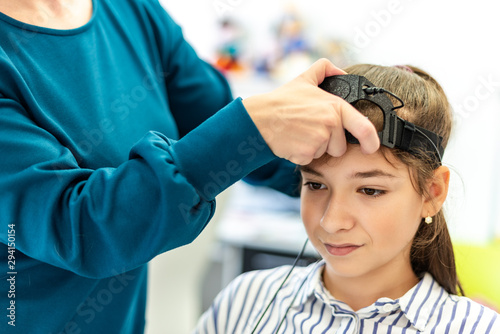 Fotografie Young teenage girl and child therapist during EEG neurofeedback session