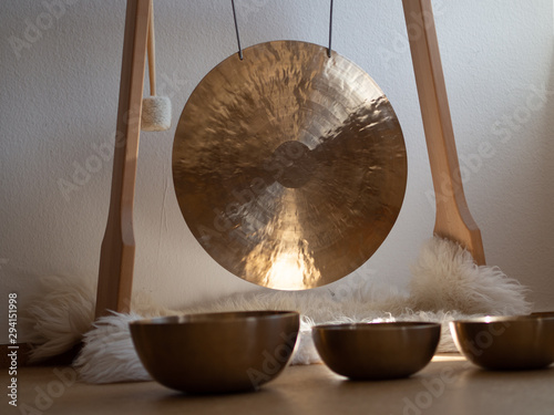 Gong in a wooden stand with tibetian singing bowls for sound bath