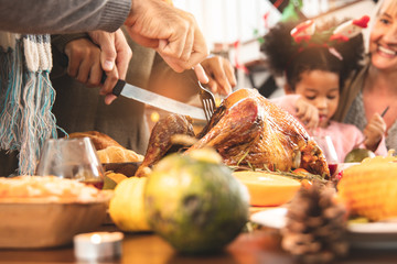 Thanksgiving Celebration Tradition Family Dinner Concept.family having holiday dinner and cutting turkey.Young black adult woman and her daughter happy..