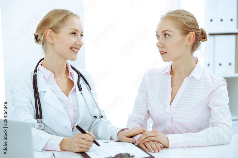 Doctor and patient talking in hospital office while sitting at the desk. Health care and client service in medicine Doctor and patient talking in hospital office while sitting at the desk. Health care and client service in medicine