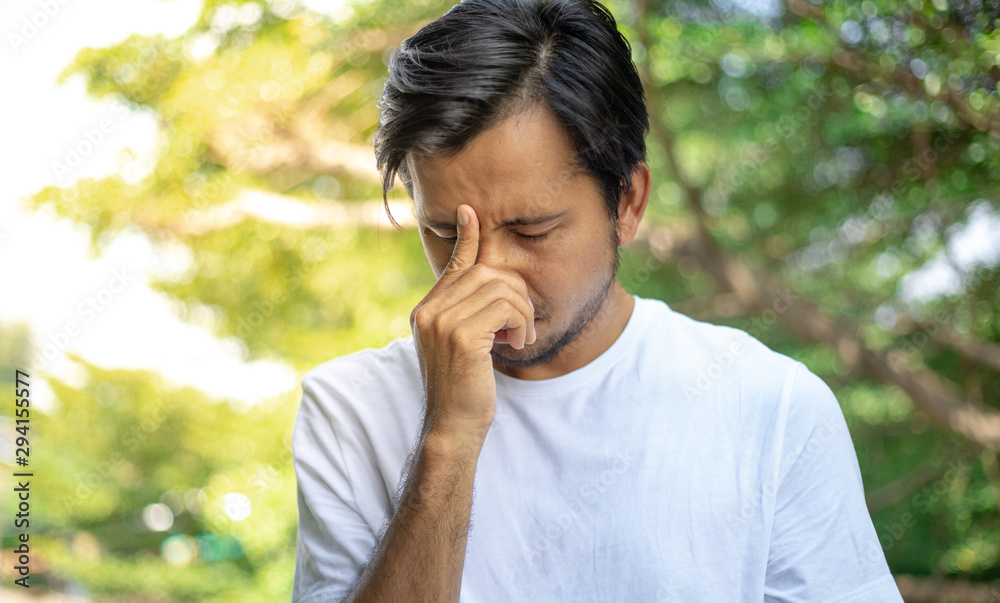 Young asian man having a headache outdoors Young asian man having a headache outdoors
