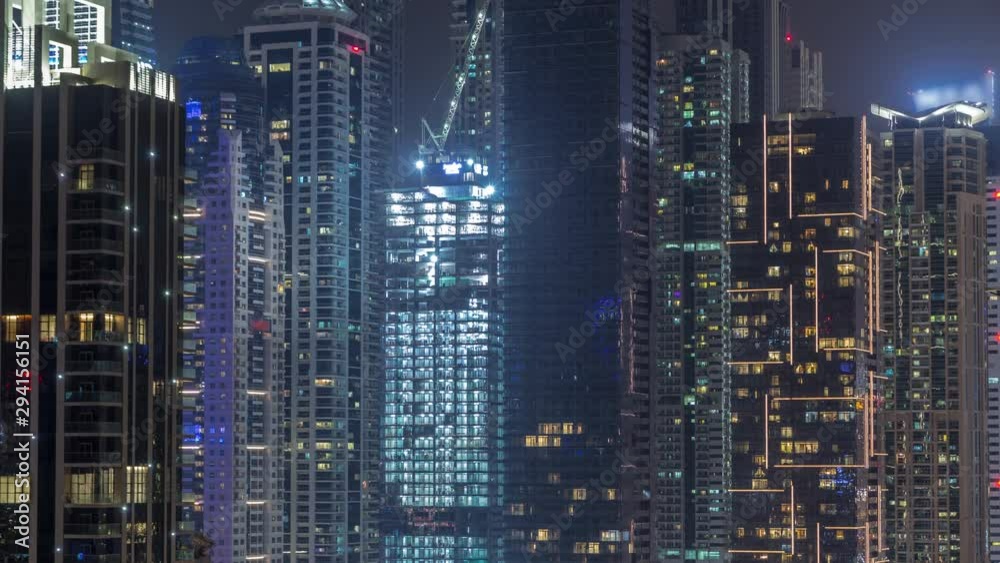 View of various skyscrapers and towers in Dubai Marina from above aerial night timelapse. Illuminated modern buildings in urban skyline with construction site View of various skyscrapers and towers in Dubai Marina from above aerial night timelapse. Illuminated modern buildings in urban skyline with construction site
