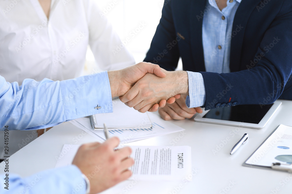 Business people shaking hands at meeting or negotiation, close-up. Group of unknown businessmen and women in modern office. Teamwork, partnership and handshake concept, toned picture Business people shaking hands at meeting or negotiation, close-up. Group of unknown businessmen and women in modern office. Teamwork, partnership and handshake concept, toned picture