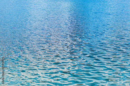 Close up abstract photo of lake, reiver, sea or ocean water surface. Beautiful smooth gradient blue and green color ripple from reflection of sun light.