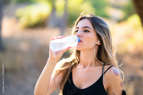 Young sport woman with a bottle of water in a park