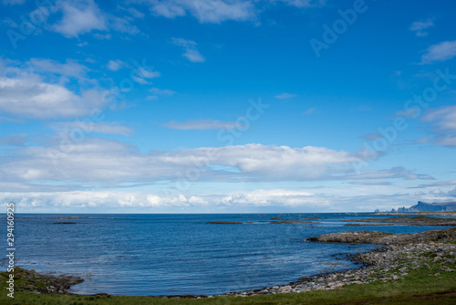 Beautiful nature landscape in North. Scenic outdoors view. Ocean with waves and mountains. Big dark stones. Dramatic storm clouds. Extreme weather  rain and wind. Explore Norway  summer adventure