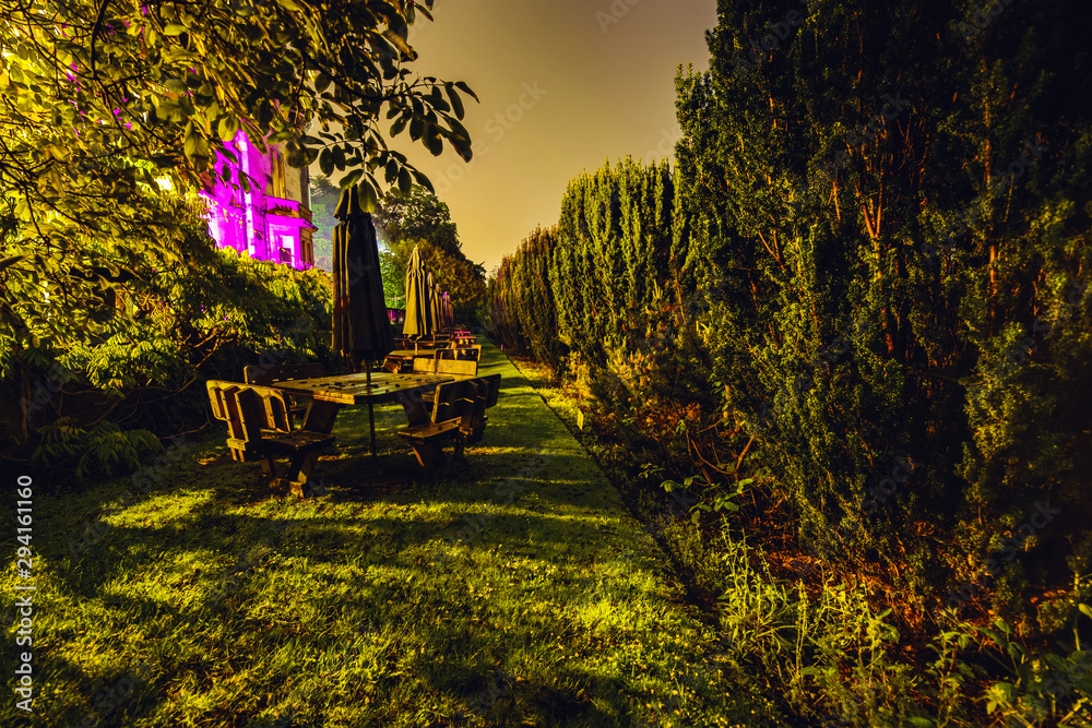 Multi-colored night lighting of the Scottish house garden.