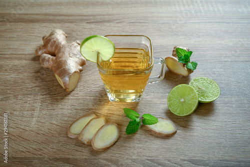 Ginger tea with lemon and mint on wooden background. photo